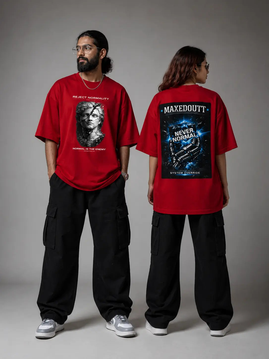 Two people wearing red t-shirts with graphic designs on a gray background